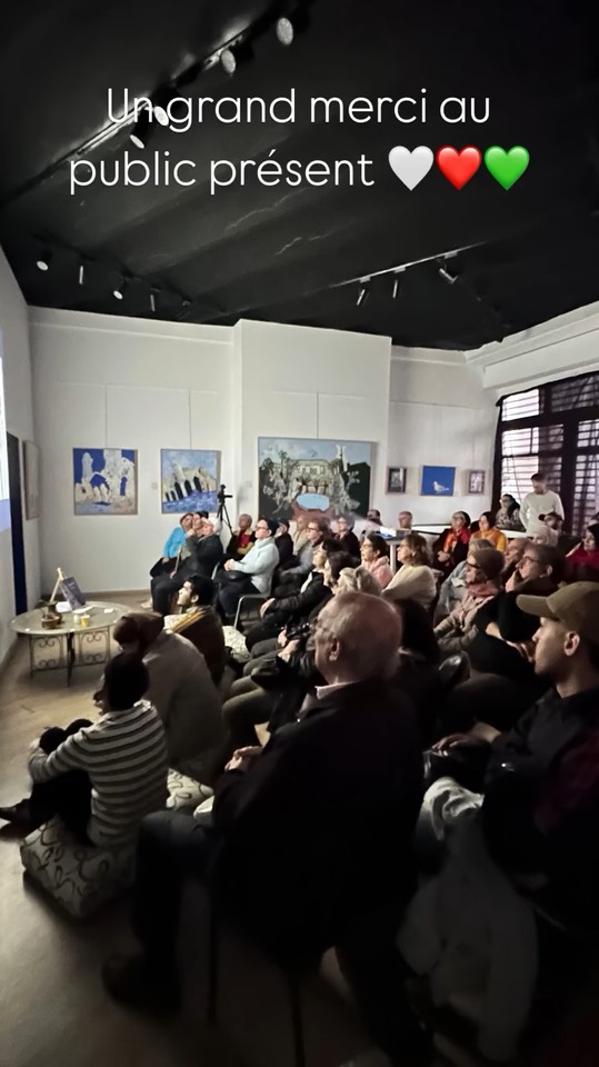 Le public de la projection, assis entre les toiles